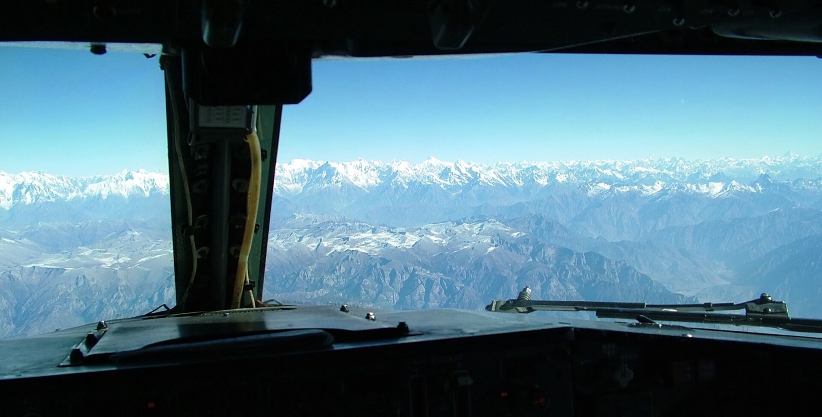 View from a flight deck window over snow-covered mountains